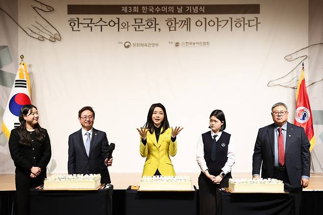 김건희 여사가 3일 서울 용산구 백범 김구기념관에서 열린 제3회 한국수어의 날 기념식에서 수어로 축하 메시지를 전달하고 있다. [연합]