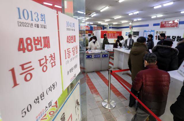 설 명절을 앞둔 1월 19일 서울 노원구 한 복권판매점 앞에 복권을 사기 위한 시민들이 길게 줄 서 있다. 뉴스1
