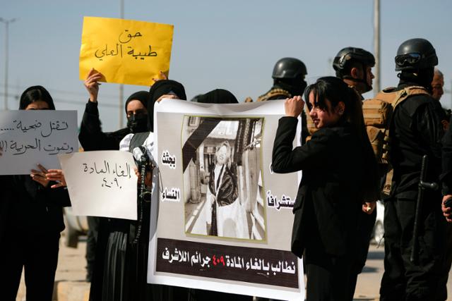이라크 시위대가 5일 디와니야에서 아버지에 의해 살해된 유튜버 티바 알-알리의 사진이 담긴 현수막을 들고 있다. 디와니야=AP 연합뉴스