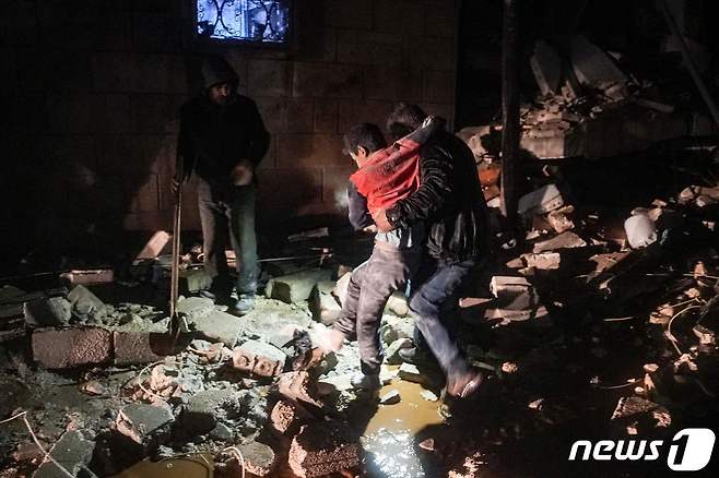 6일(현지시간) 튀르키예에서 리히터 규모 7.9의 강진이 발생한 가운데 시리아 서북부 진디레스에서도 건물이 무너지는 피해가 속출했다. 한 남성이 건물 잔해에서 부상 당한 아이를 구출해 내고 있다. 2023.2.6. ⓒ AFP=뉴스1 ⓒ News1 김성식 기자