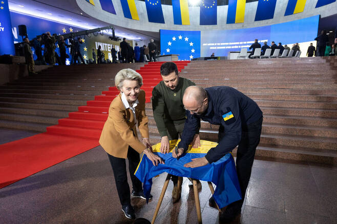 지난 2일(현지시각) 우르줄라 폰데어라이엔 유럽연합 집행위원장(왼쪽부터), 볼로디미르 젤렌스키 우크라이나 대통령, 데니스 슈미할 우크라이나 총리가 수도 키이우에서 정상회담을 시작하기에 앞서 우크라이나 국기에 서명하고 있다. 키이우/로이터 연합뉴스