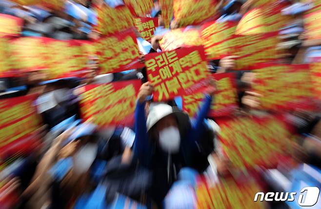 민주노총 서비스연맹 전국택배노동조합원들이 서울 세종대로 광화문사거리 일대에서 열린 '임금삭감, 쉬운 해고 노예계약 저지' 우체국 택배 노동자 총력 결의대회에서 노예계약서를 거부하며 손 피켓을 들고 있다. 2022.6.13/뉴스1 ⓒ News1 이동해 기자
