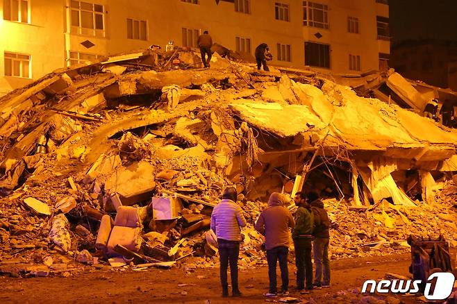 7일(현지시간) 튀르키예(터키) 남동부 디야르바키르에서 시민들이 무너진 건물을 바라보고 있다. 이번 지진으로 튀르키예와 시리아에서 집계된 사망자 수는 4300명을 훌쩍 넘기고 있다. ⓒ 로이터=뉴스1 ⓒ News1 박재하 기자