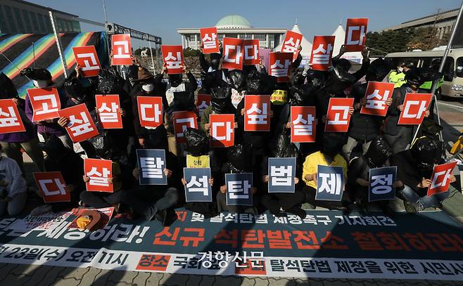 환경운동연합 등 환경단체 회원들이 23일 서울 국회 앞에서 열린 기자회견에서 탈석탄법 제정을 촉구하는 퍼포먼스를 하고 있다. 성동훈 기자