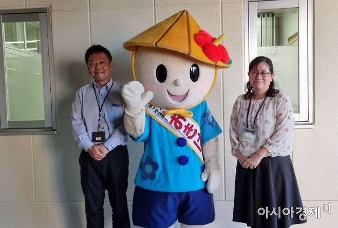 모리구치 마리 오키나와시청 시민건강과장(오른쪽)과 아라카키 아키히로 건강추진계장(왼쪽), 그리고 오키나와 건강 증진 캐릭터 '오키와군'.