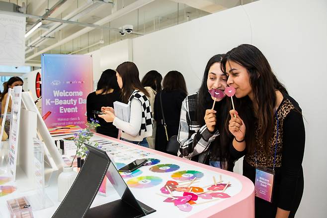외국인 관광객이 셀프 뷰티체험존에서 퍼스널컬러를 체험하고 있는 모습