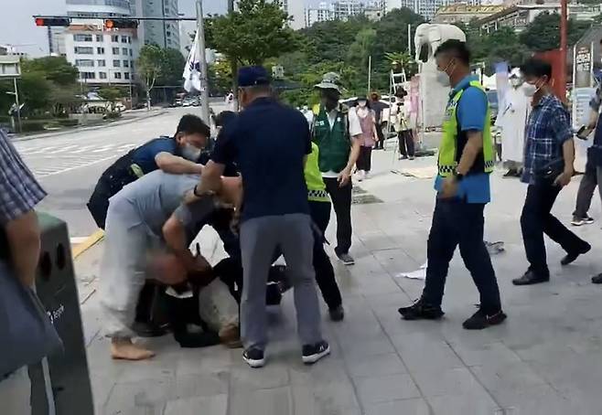 [서울=뉴시스] 14일 서울 강남의 유명 사찰인 봉은사 앞에서 자승 전 총무원장 측의 조계종 총무원장 선거 개입 등을 비판하는 1인 시위를 준비하던 조계종 노조원이 스님들로부터 폭행을 당하는 일이 벌어졌다. (사진=조계종 노조 제공 영상 캡처) 2022.08.14. photo@newsis.com *재판매 및 DB 금지