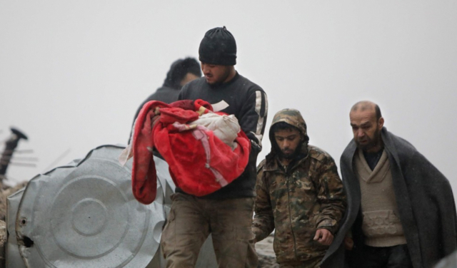 한 시리아인 아버지가 이미 숨진 아기를 품에 안고 건물 잔해에서 벗어나고 있다. AFP 연합뉴스
