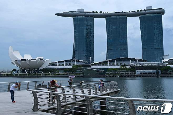 싱가포르 랜드마크 마리나베이샌즈 호텔이 보이는 공원에서 여유를 즐기는 시민들의 모습. ⓒ AFP=뉴스1 ⓒ News1 최서윤 기자