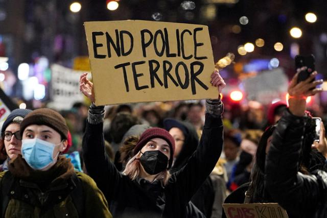 올해 초 경찰의 폭행으로 숨진 타이어 니컬스의 사망 사건에 항의하기 위해 지난달 28일 미국 뉴욕에서 열린 시위 도중 한 여성이 '경찰은 테러를 멈춰라'라고 기재된 팻말을 들어 보이고 있다. 뉴욕=로이터 연합뉴스