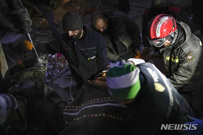 [엘비스탄=AP/뉴시스] 8일(현지시간) 튀르키예 엘비스탄에서 레바논 구조대가 지진으로 파괴된 건물 잔해에서 한 여성의 시신을 수습하고 있다. 튀르키예와 시리아를 강타한 지진으로 사망자 숫자가  1만2천 명을 넘은 것으로 나타났으며 생존자를 구할 수 있는 골든 타임이 얼마 남지 않은 상황에서 강추위로 어려움이 가중되고 있다. 2023.02.09.