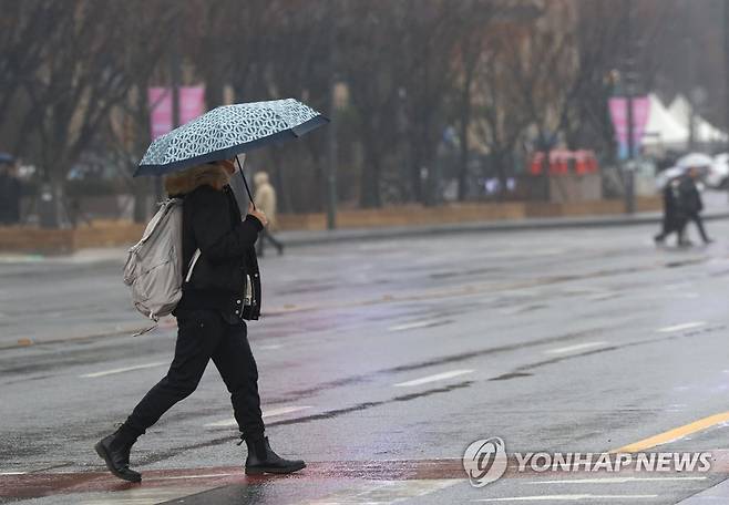 서울 광화문광장 인근에서 시민이 우산을 쓴 채 횡단보도를 건너고 있다. [연합뉴스 자료사진]