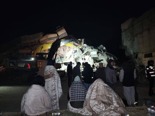 강진의 진원지인 튀르키예 카라만마라슈의 부서진 건물 앞에서 담요를 두른 실종자 가족들이 수색 작업을 하염없이 보고 있다. 카라만마라슈=신은별 특파원