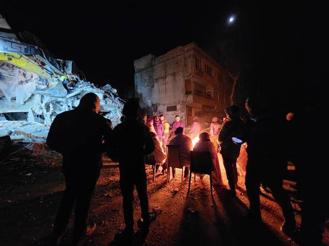 8일(현지시간) 튀르키예 카라만마라슈에서 실종자 수색 작업 현장 옆으로 모닥불 옆에 모여 있는 실종자 가족과 주민들이 보인다. 카라만마라슈=신은별 특파원