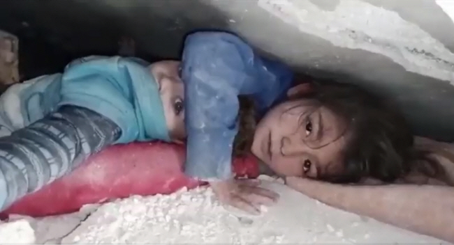 튀르키예와 시리아를 강타한 지진으로 무너진 건물 잔해 속에서 7세 시리아 소녀가 7일(현지시간) 동생의 머리를 보호하기 위해 구조물을 팔로 떠받친 채 구조를 기다리고 있다. 두 아이는 매몰된 지 17시간 만에 극적으로 구조됐다.    트위터 캡처