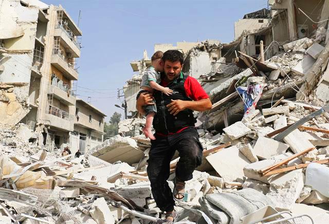 시리아 정부군과 반군의 임시 휴전이 끝난 2016년 9월 시리아 알레포에서 공습이 계속되는 가운데 한 시민이 무너진 건물 잔해에서 구조한 아이를 안아 옮기고 있다. 알레포=AFP 연합뉴스
