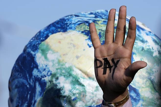 환경운동가들이 기후위기를 촉발한 선진국들이 손실을 입은 개발도상국에 보상할 것을 촉구하며 ‘지불’이라는 글자가 쓰인 손바닥을 펼쳐 보이고 있다. 샤름엘셰이크 | AP연합뉴스