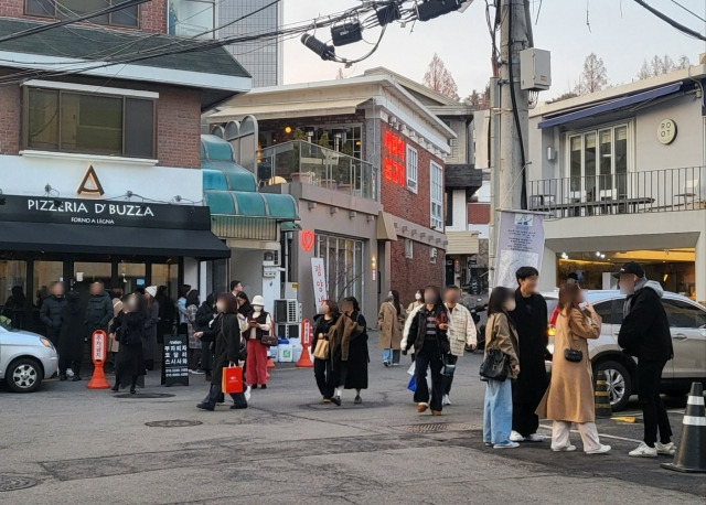 시민들이 지난 10일 서울 용산구 한남동 길거리에서 삼삼오오 무리를 지어 걷고 있다. 지난달 31일부터 한남동 리움미술관에서 열린 미우라치오 카텔란 전시가 매진을 이어가면서 침체에 빠졌던 이태원 상권 일부는 회복 조짐을 보인다.