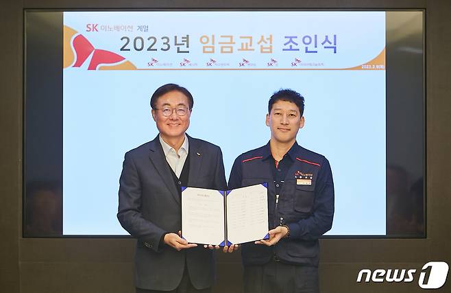 9일 오전 서울 종로구 SK서린빌딩에서 열린 SK이노베이션 ‘2023년도 임금교섭 조인식’에서 김준 SK이노베이션 부회장, 박율희 SK이노베이션 노조위원장(왼쪽부터)이 노사 합의서를 함께 들며 기념촬영을 하고 있다.(SK이노베이션 제공)