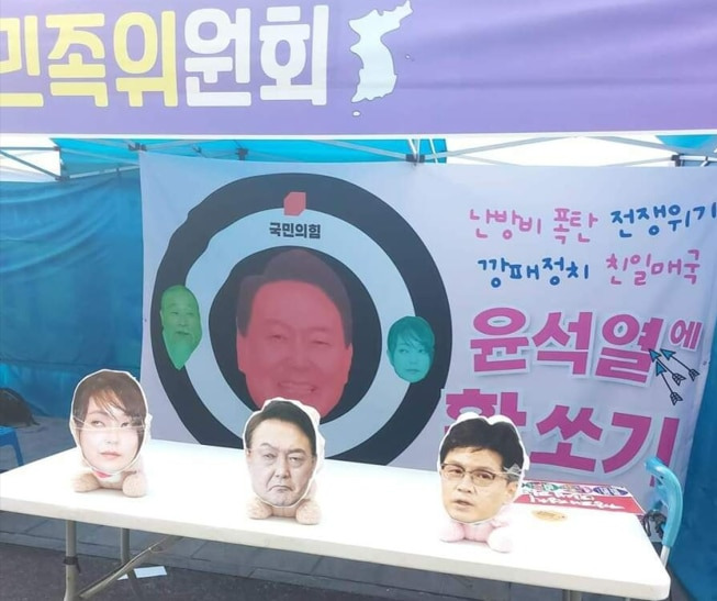 윤석열 정부 퇴진 집회에서 진행된 활 쏘기 퍼포먼스. 김건희 여사, 윤석열 대통령, 한동훈 법무부 장관의 얼굴을 인형에 붙인 뒤 이를 장난감 활로 쏘는 방식이다. /온라인 커뮤니티