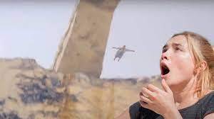 영화 '미드소마'에서 한 노인이 투신하는 모습을 여주인공이 공포에 질린 모습으로 보고 있다./미드소마