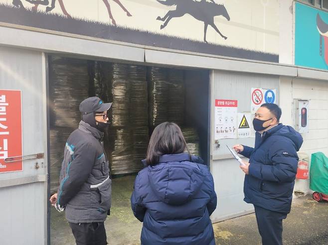 한국마사회 부산경남본부 소방안전관리자가 사료창고 앞에서 특수가연물 취급기준을 설명하며 점검하고 있다. 한국마사회 부산경남본부 제공