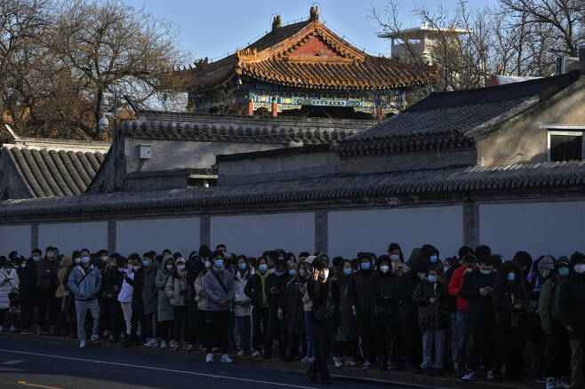 13일 중국 베이징의 용허궁 사원 앞에 주민들이 줄 서 있다. 베이징/AP 연합뉴스