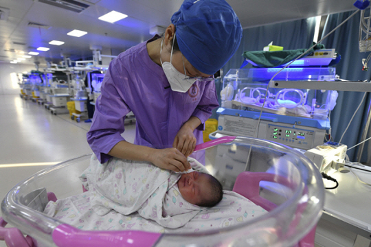 지난 17일 중국 안후이성의 한 산부인과 병원에서 간호사가 신생아를 돌보고 있다. AP 뉴시스