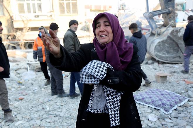 12일(현지시간) 튀르키예 남동부 도시 아디야만에서 주민 아딜레 이시크가 건물 잔해에 갇힌 그녀의 21살 아들이 구조되길 기다리고 있다. 지난 6일 시리아와 인접한 튀르키예 남동부에서 규모 7.8의 강진이 발생해 현재 양국의 누적 사망자 수가 3만3천명을 넘어섰다. [연합]