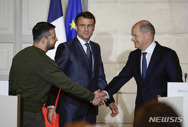 [파리=AP/뉴시스] 볼로디미르 젤렌스키(왼쪽) 우크라이나 대통령이 지난 8일(현지시간) 프랑스 파리 엘리제궁에서 에마뉘엘 마크롱(가운데) 프랑스 대통령, 올라프 숄츠 독일 총리와 공동 기자회견을 하면서 숄츠 총리와 악수하고 있다.