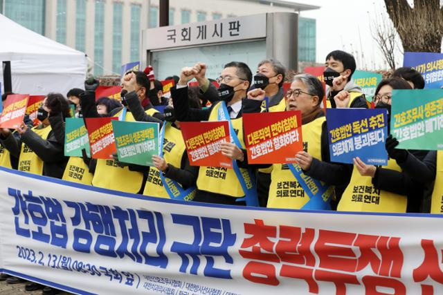 대한의사협회, 대한간호조무사협회 등으로 구성된 보건복지의료연대 구성원들이 13일 서울 영등포구 국회의사당 앞에서 간호법 강행처리 규탄 총력투쟁 선포식을 하고 있다. 뉴스1