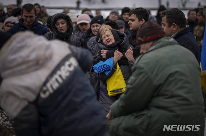 [르비우=AP/뉴시스] 지난 7일(현지시간) 우크라이나 르비우에서 한 여성이 러시아군과의 전투 중 전사한 아들의 장례식 도중 아들의 유해가 매장되는 모습을 보면서 오열하고 있다. 2023.02.08.