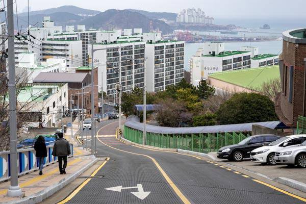 국제신문 취재진이 영도구 광명고 옆 급경사길을 따라 내려가고 있다.  이원준 기자