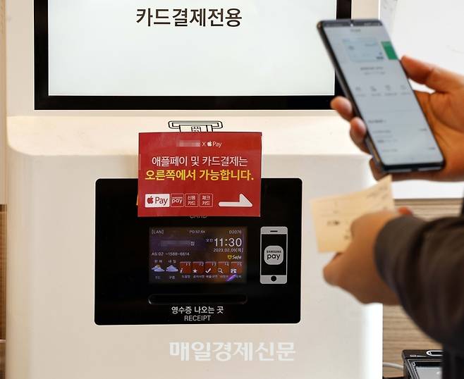 다음 달 초부터 ‘애플페이’ 이용이 가능해지면서 삼성페이와 정면 승부를 펼치게 된 가운데 9일 경기도 성남시에 애플페이 도입을 준비 중인 한 식당 키오스크에 관련 안내문구가 붙어 있다.  2023.2.9 [김호영 기자]