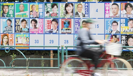 지난 2022년 7월 10일 도쿄도 스미다구에 설치된 일본 참의원 선거 후보자 안내판 앞으로 자전거를 탄 사람이 지나가고 있다. 연합뉴스
