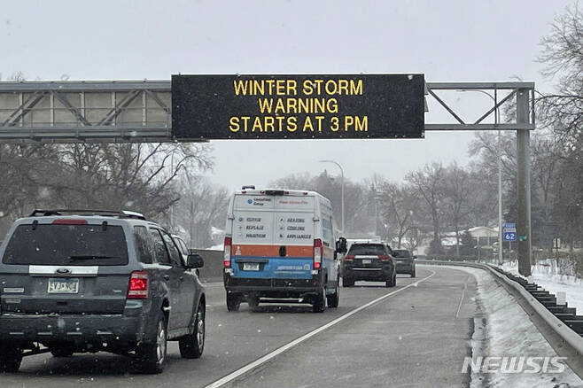 [미네아폴리스생폴=AP/뉴시스] 21일(현지시간) 차량들이 미네아폴리스 세인트폴 국제 공항 인근 3W 고속도로에서 "오후 3시부터 겨울 폭풍이 시작된다"는 경보 표지판 아래를 지나고 있다. 2023.02.22.