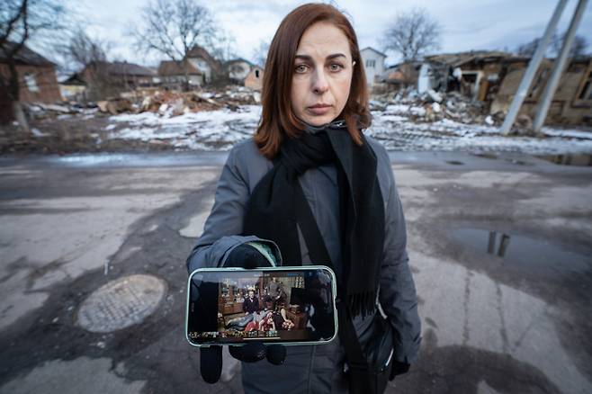 러시아군의 미사일 공격으로 집과 가족을 모두 잃고 혼자 살아남은 스비틀라나 젤다크가 폐허가 된 자신의 집 앞에서 전쟁 전에 찍었던 가족사진을 보여주고 있다. 체르니히우 |  KISH KIM·다큐앤드뉴스코리아