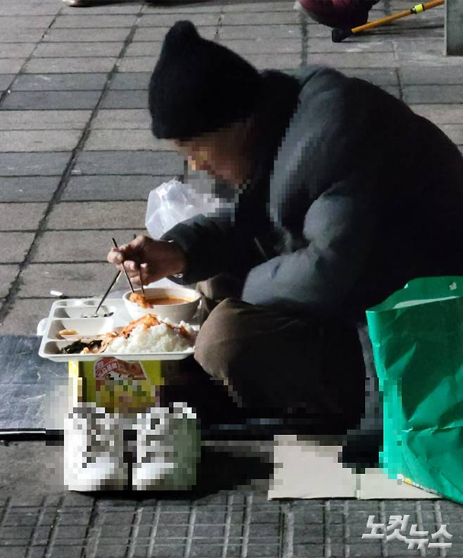 저녁 시간 정나눔터에 노숙인들이 너무 많이 몰리자 자리가 부족해 밖에 앉아서 식사를 하고 있는 한 노숙인. 박창주 기자