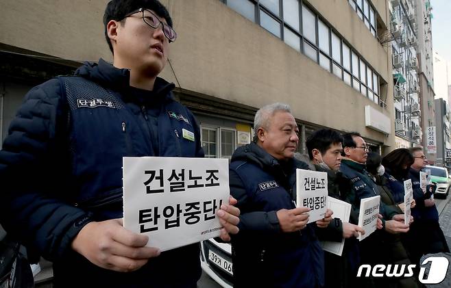경찰이 건설현장 불법행위와 관련해 민주노총 인천본부를 압수수색 중인 2일 오전 민주노총 인천본부 앞에 노노조원들이 경찰 압수수색을 항의하는 내용의 피켓을 들고 서 있다.2022.2.2/뉴스1 ⓒ News1 정진욱 기자