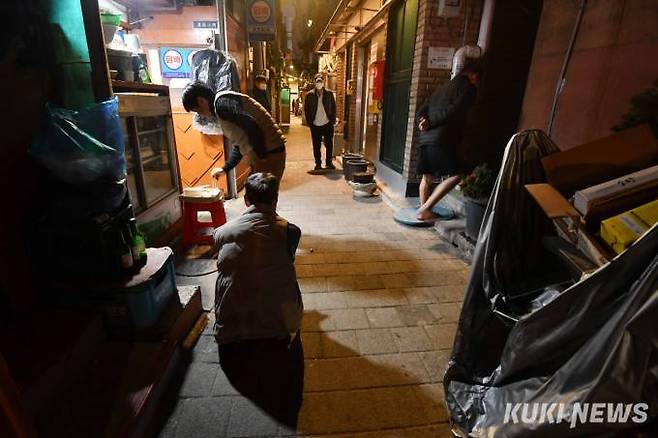 익선동 한옥거리 바로 맞은편에 위치한 돈의동 쪽방촌 전경. 늦은 시간 일터에서 돌아온 한 주민이 슈퍼에서 간편한 식품을 구해 허기를 달래고 있다.