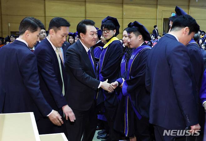 [서울=뉴시스] 홍효식 기자 = 윤석열 대통령이 27일 서울 서대문구 연세대학교에서 열린 2023년 2월 학위수여식에서 졸업생들과 악수하고 있다. (대통령실통신사진기자단) 2023.02.27. yesphoto@newsis.com