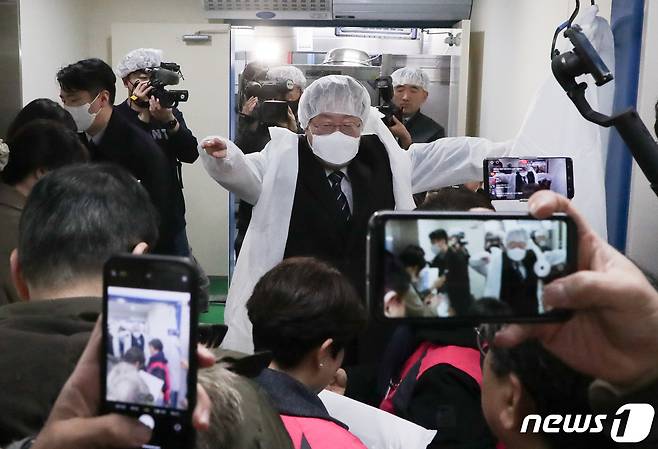 이재명 더불어민주당 대표가 28일 서울 은평구 수색초등학교에서 열린 학교급식노동자 폐암 진단 관련 민생현장 방문에서 교내 조리실 안으로 들어가기 전 위생복을 입고 있다. (공동취재) 2023.2.28/뉴스1 ⓒ News1 송원영 기자