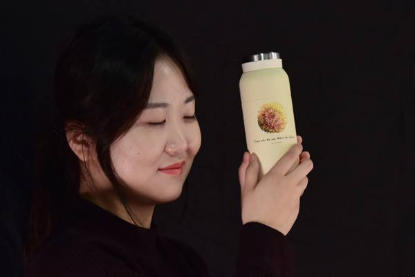 시각장애 디자이너 허은빈 작가가 자신의 작품 ‘꽃’을 모티브로 디자인한 텀블러를 들고 포즈를 취하고 있다.