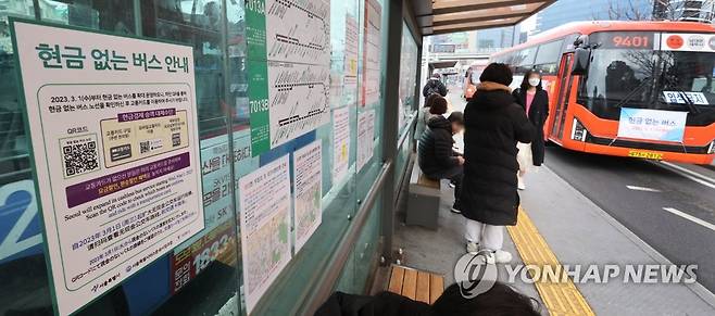 버스정거장에 부착된 현금없는버스 안내문 (서울=연합뉴스) 최재구 기자 = 서울시가 기존 18개 노선·436대였던 '현금 없는 버스'를 108개 노선·1천876대로 늘려 운행을 시작한 1일 서울역 앞 버스 정거장에 관련 홍보불이 부착되어 있다.  2023.3.1 jjaeck9@yna.co.kr