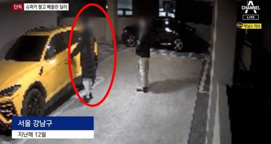 수퍼카를 소개해준 뒤 나중에 차를 훔쳐간 딜러 A씨(붉은 원). A씨가 직접 차를 운전하려 운전석 쪽 차 문을 열고 있다. A씨 옆에 선 남성 역시 A씨에게 차를 소개받기로 하고 돈을 주고 차를 못 받고 있다가 ″차를 가져다 준다″는 말에 따라 온 피해자다. 사진 채널A 캡처