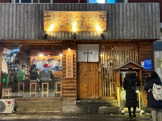 People line up outside Mifendang to order their food at the kiosk. [LEE JUNG-JOO]