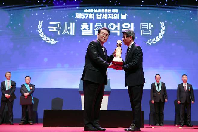 윤석열 대통령이 3일 서울 강남구 코엑스에서 열린 제57회 납세자의 날 기념식에서 기아 송호성 대표이사에게 국세 7천억원 고액납세의 탑을 수여하고 있다. 대통령실 제공