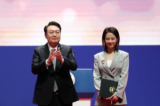 윤석열 대통령이 3일 서울 강남구 코엑스에서 열린 제57회 납세자의 날 기념식에서 모범납세자로 선정된 배우 송지효(본명 천수연)에게 대통령표창을 수여한 뒤 축하하고 있다. 대통령실 제공