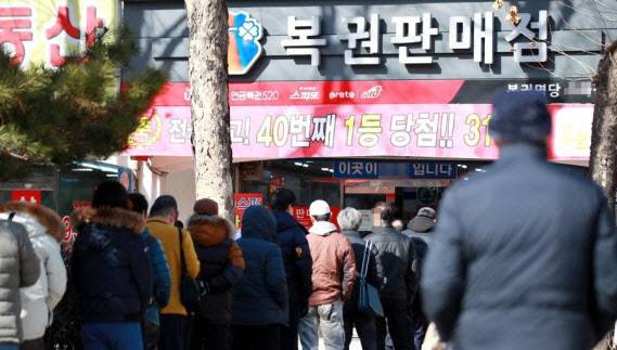 시민들이 로또 1등이 당첨된 복권판매점 앞에서 복권을 사기 위해 기다리고 있다. (사진=연합뉴스)