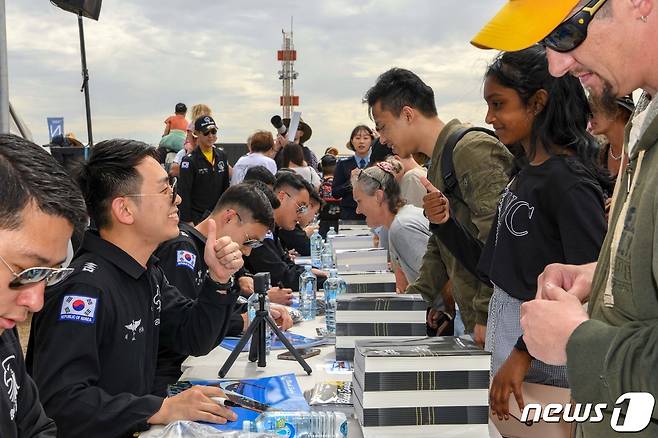 4일(현지시간) 호주 맬버른 애벌론 공항에서 열린 '2023 호주 애벌론 국제에어쇼'에서 대한민국 공군 특수비행팀 블랙이글스(Black Eagles) 2번기 조종사 길두현 대위가 기념 사인 행사장을 찾은 관람객과 대화하고 있다. (공군 제공) 2023.3.5/뉴스1